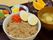 黒いお盆の上には丼、野菜の煮物、漬物、汁椀、フルーツがきれいに並んでいる。栄養バランスや素材の大きさ、柔らかさに配慮されたメニュー。