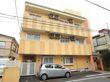 明るい色合いの外観である。マンションを思わせる建物で、コンクリートでできた赤い門が入居者様をあたたかく迎える。