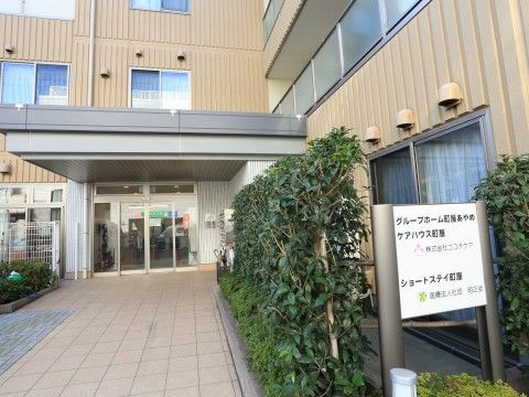 「グループホーム町屋あやめ」の外観。茶系の落ち着いた色合いの建物。