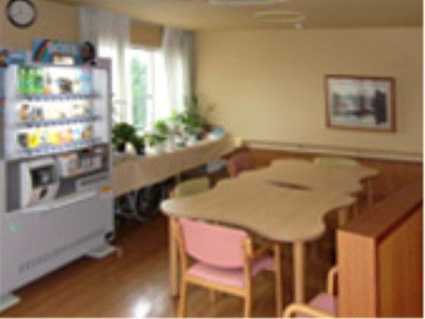 室内の床はフローリングになっており、自動販売機が設けられている。テーブル、手すり付きの椅子が置かれ、壁には絵画が飾られている。