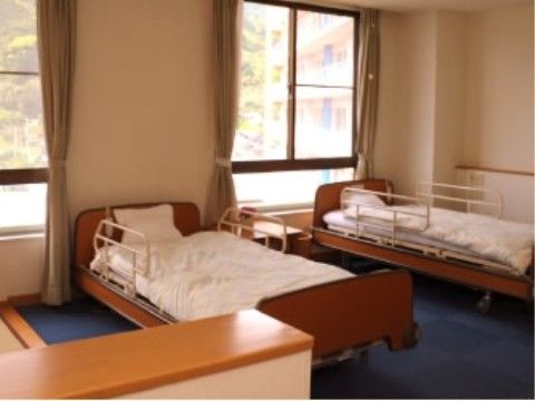転落を防止する柵があるベッドが２台設置された明るい居室