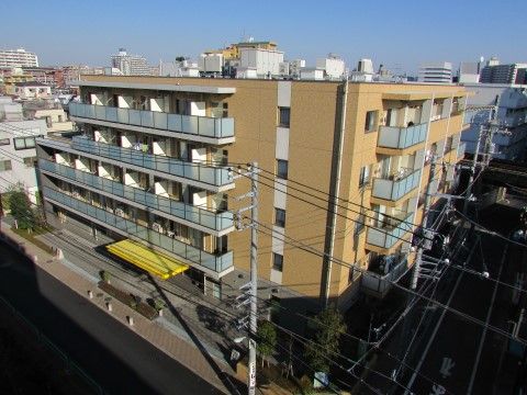交差点の角に建つ、上階にベランダが設置された施設の外観