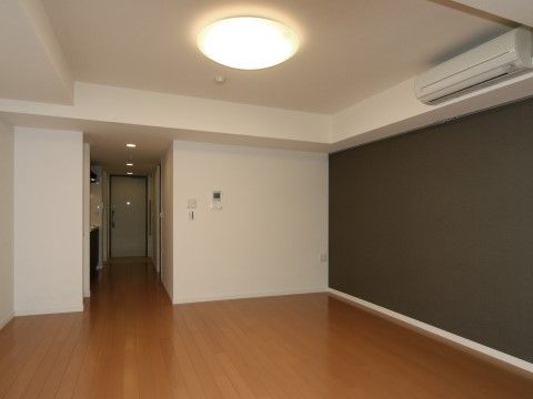 フローリングの床は部屋の入口まで段差のないバリアフリー。白い壁は、一面のみ黒のアクセントウォールになっている。