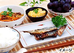 焼き魚とご飯、ぶどうのデザートが付いたメニュー