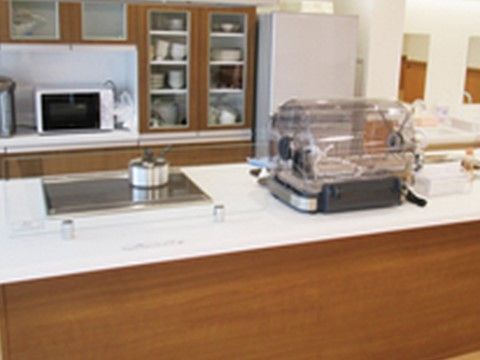 食堂内にあるキッチン。コンロは火事の心配がない電気タイプ。カウンター式なので、スタッフからも入居者様側からもよく見える。