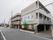 施設は３階建てである。施設前の道路は広い。施設の周りには植え込みがあり、緑が豊富な空間になっている。