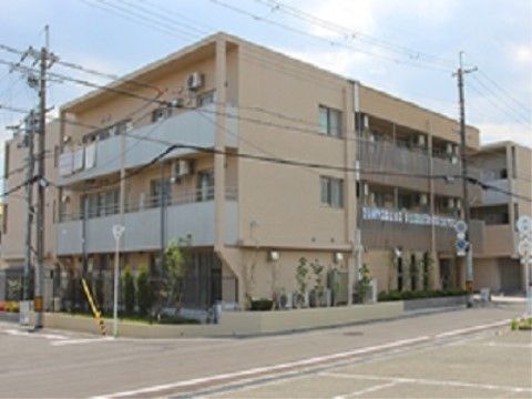 ベランダが設置された、ベージュ色が基調となった施設の外観