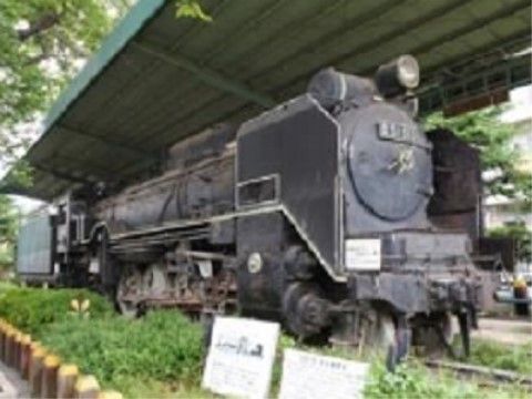 公園には蒸気機関車が展示され、屋根が設置されている。周囲には木々が立ち並び、緑が豊かな環境になっている。