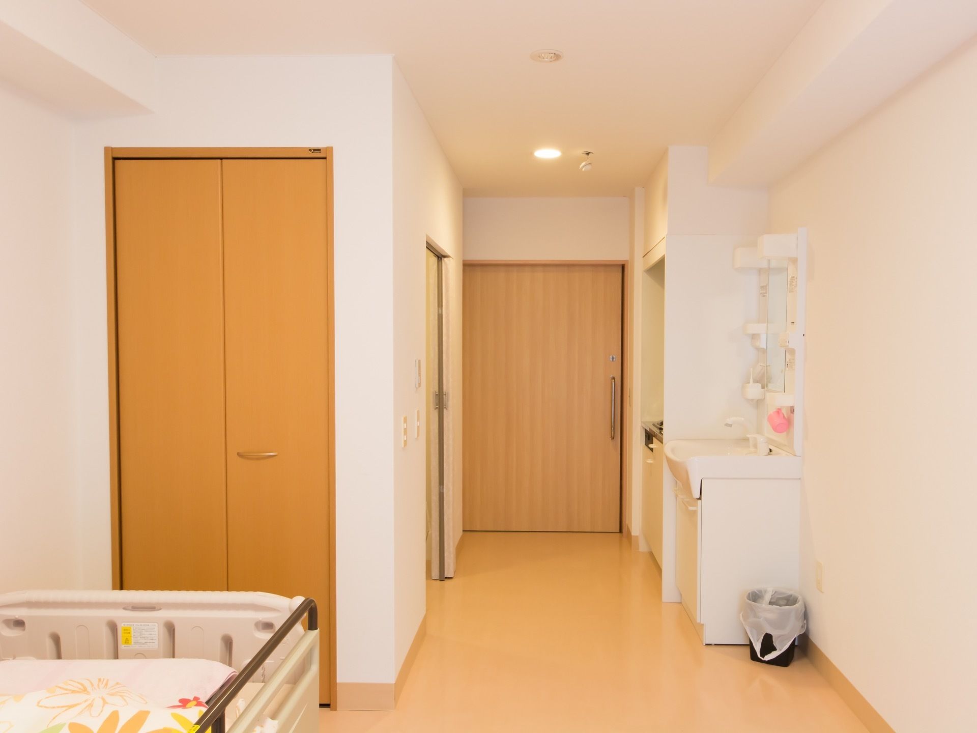 居室にはベッドが置かれている。ベッドの傍には折戸の扉が付いたクローゼットがある。キッチン台の横には洗面台が設置されている。