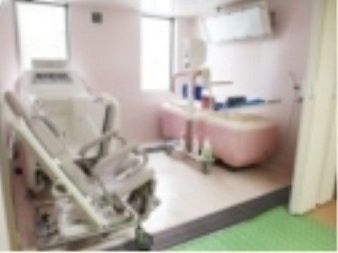 窓があるタイル貼りの浴室に、座位浴と寝位浴が可能な特殊介助浴槽が置いてある。座って入る方には専用の車椅子が付いている。