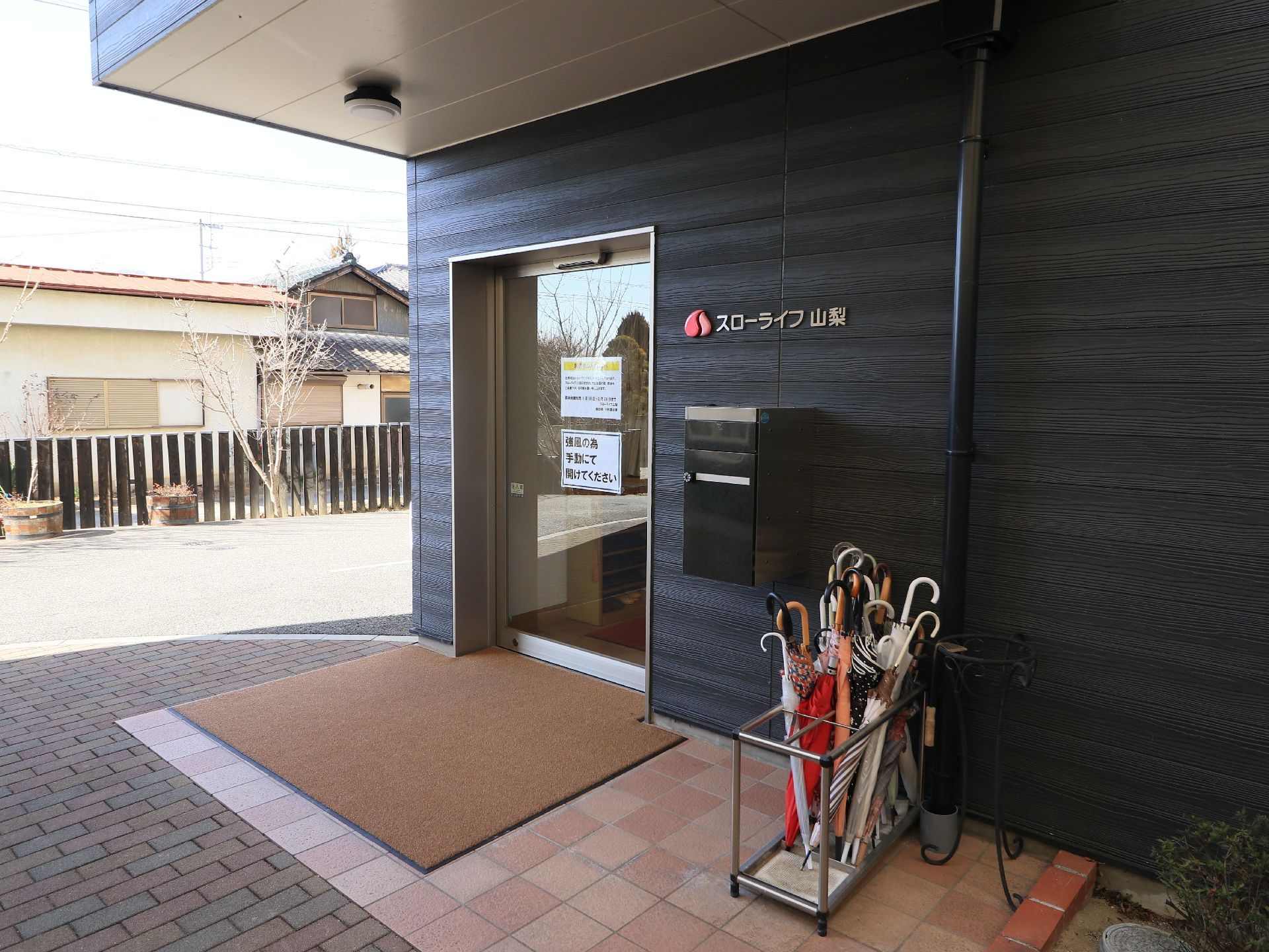 玄関周りの床は段差なく整え、上部には大型の屋根を設置している。扉はガラス張りの自動ドアで見通しが良い。