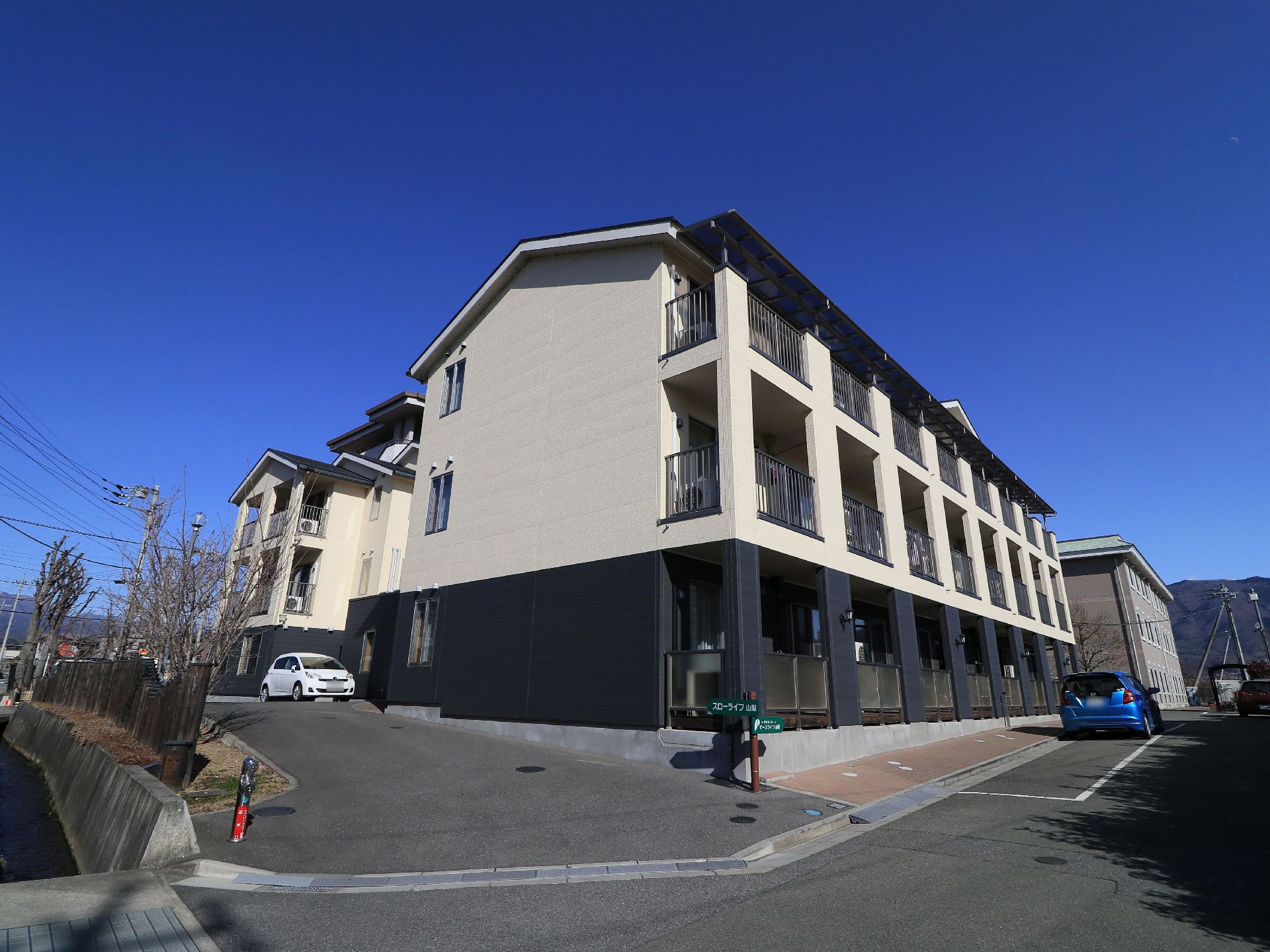 施設は３階建てで、外壁は黒色と白色で統一されている。居室には全室ベランダが設けられており、アパートのような作りになっている。