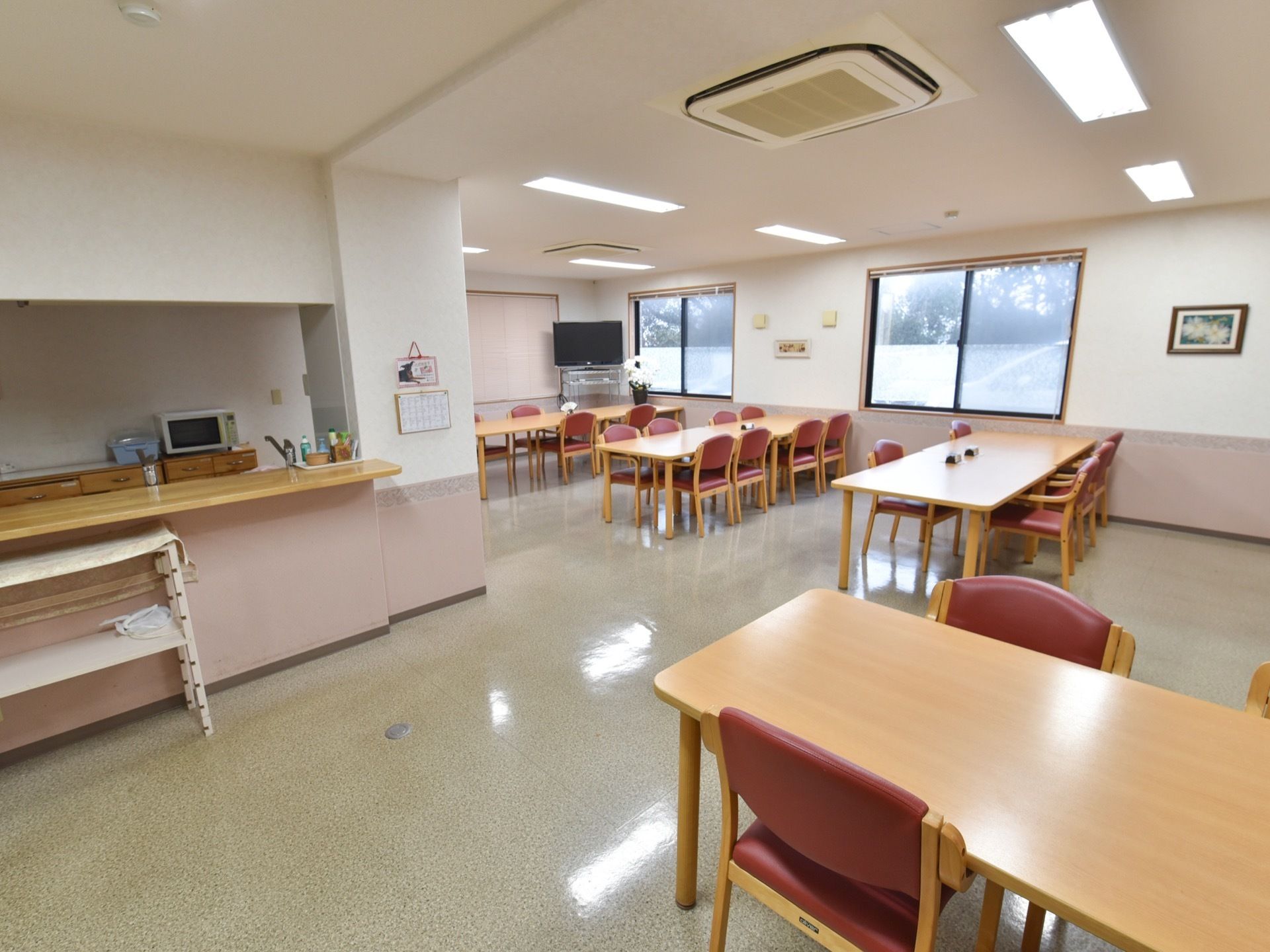 対面式キッチンが併設されている広々とした食堂である。ダイニングテーブルがゆったりとした間隔をとって配置されている。
