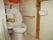 白く磨かれたタイルで囲まれたトイレはカーテンで仕切られた作りとなっているため、入居者様がすぐに利用しやすい。