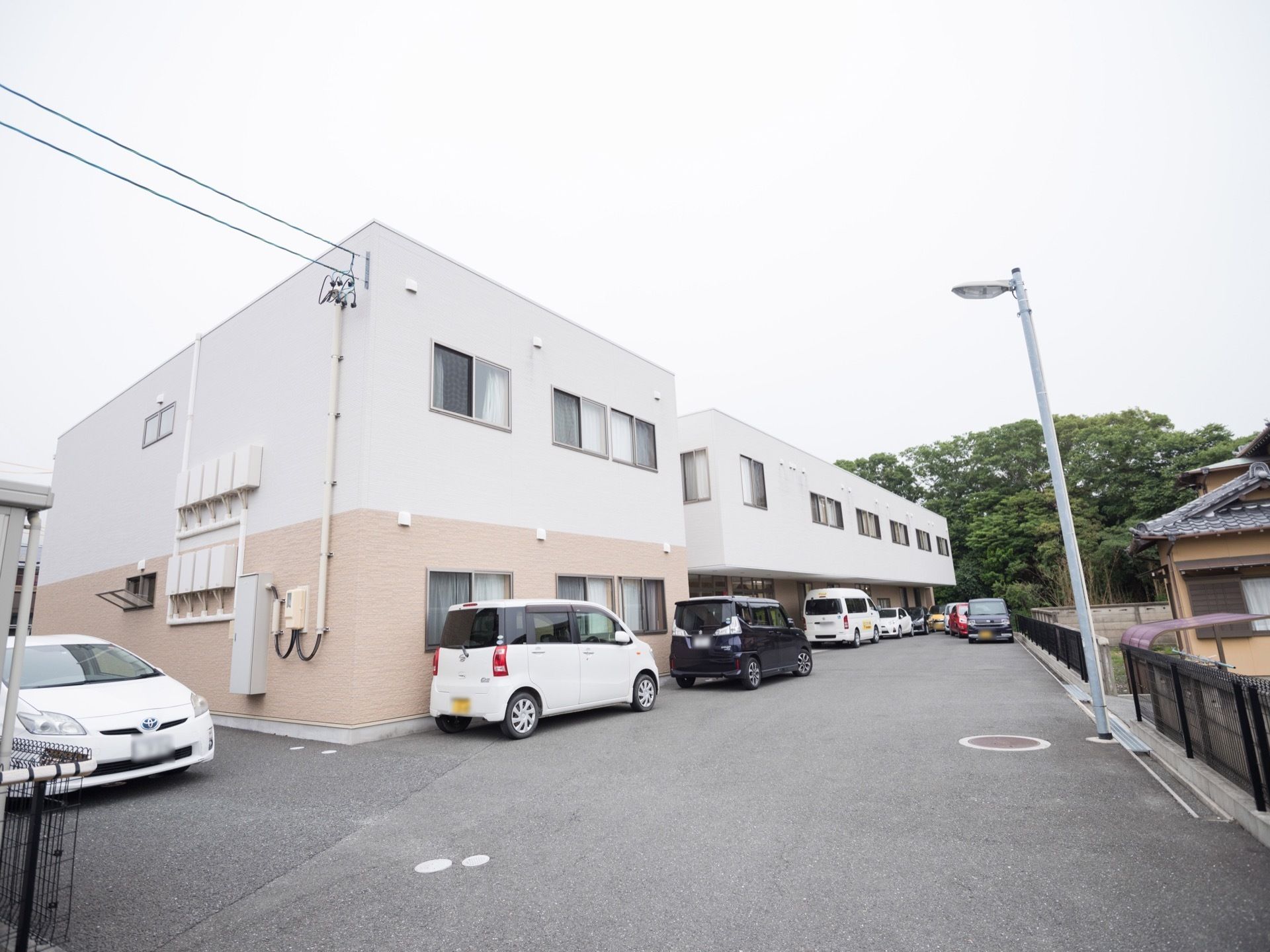 建物の裏手には広いスペースがあり、駐車スペースとして活用されている。敷地内はバリアフリーなので、道路も舗装されていて安全に通行できる。