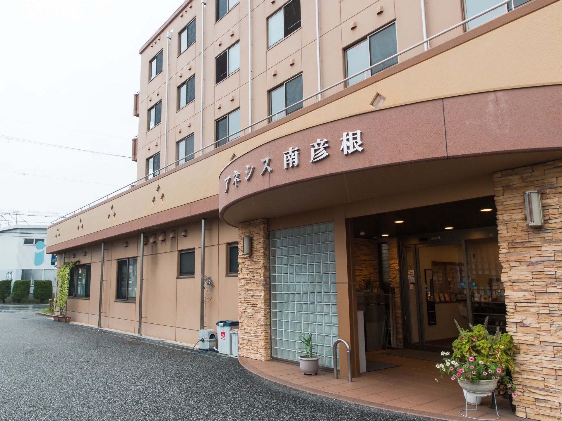 施設は、濃淡のあるえんじ色の外壁の５階建てである。敷地内は車が出入りできる十分なスペースがある。