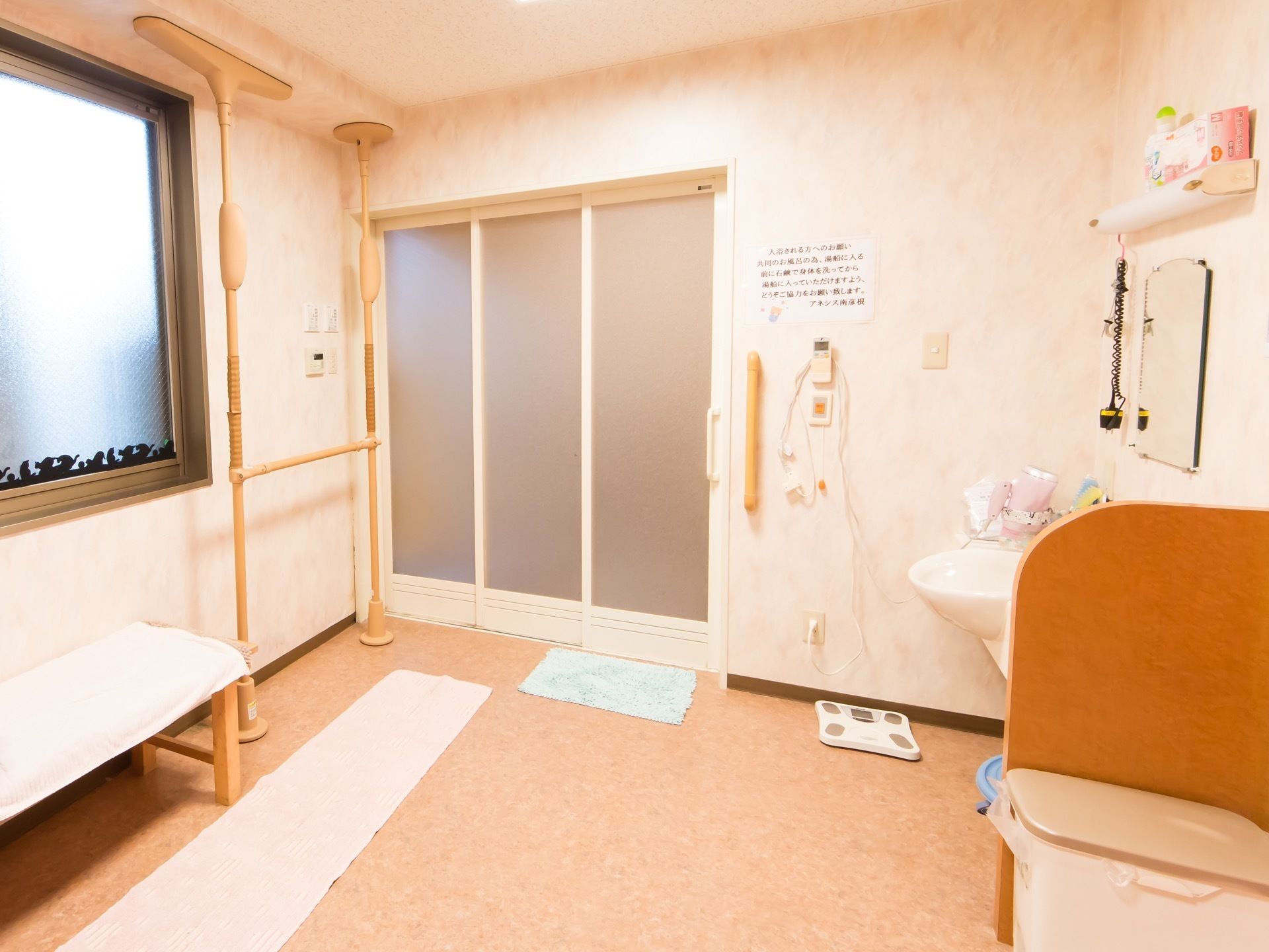 浴室の前の脱衣所は、広々としたスペースで、洗面台や長ベンチ、体重計などが設置され、複数人いても窮屈にならない。
