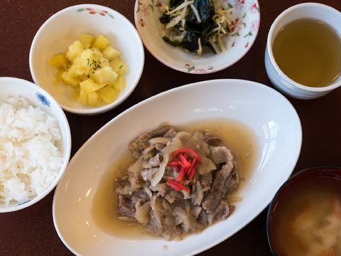 ご飯と汁物、肉のメインおかずに小鉢が2つ、そして、お茶が添えられた1食のメニューである。栄養バランスと品数が考慮された食事である。