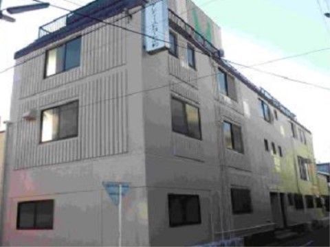 「アレアイーストコート中村」の外観。周辺は、静謐で住宅街がある、4階建ての灰色の外壁である。