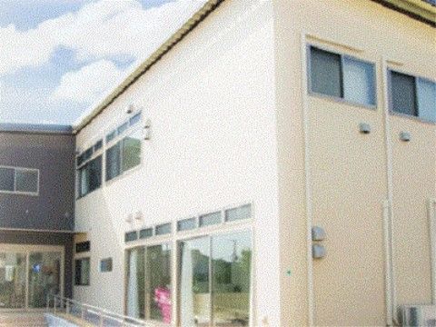 ２階建てになっており、大きな窓が複数設置された施設の外観