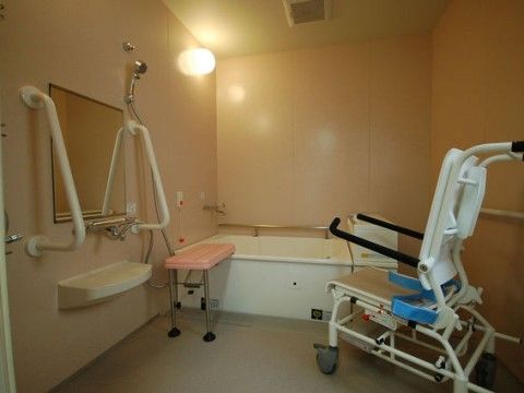 リフト浴が可能な個浴室には、シャワーキャリーが用意されている。壁に手すりが取り付けられており、浴槽に移乗台が設置されている。