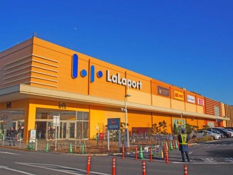ららぽーと新三郷は、オレンジ色の外観が特徴的な建物である。敷地内には、広大な駐車場が完備されている。