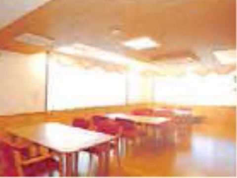 窓が大きくとられ、自然光が降り注ぐ明るい食堂。テーブルと椅子が置かれており、ピンクの背もたれの椅子はゆったりとした安らぎを感じさせる。