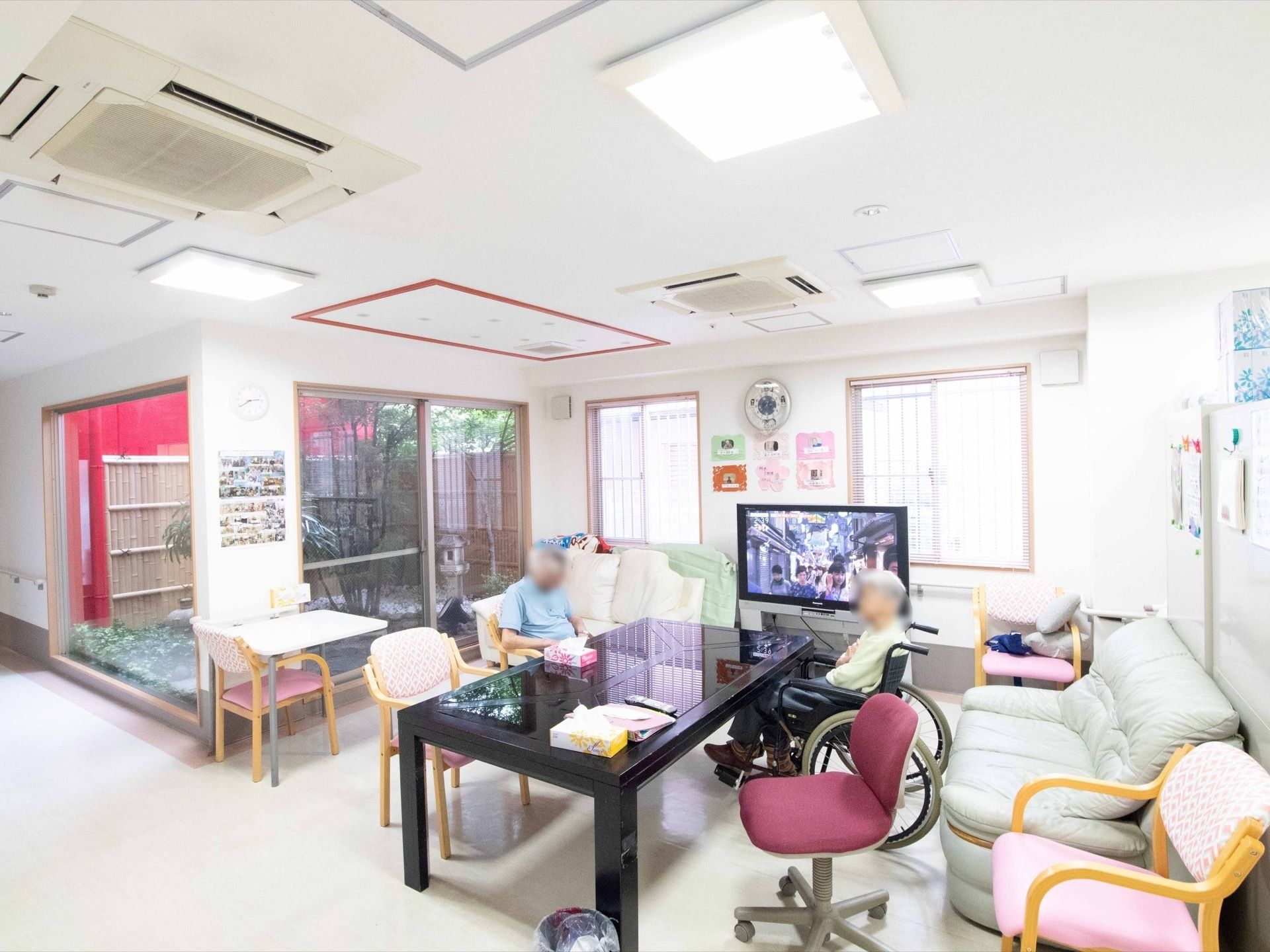 大きなテーブルや椅子、ソファーが置かれた明るい共有スペースである。窓からは庭園を眺めることができる。