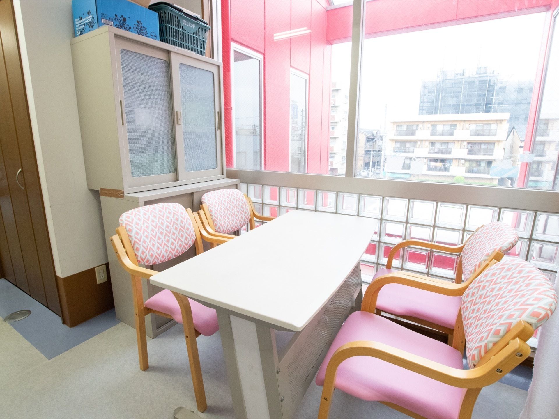 白いテーブルが1つとピンク色の椅子が４つ設置されている休憩スペース