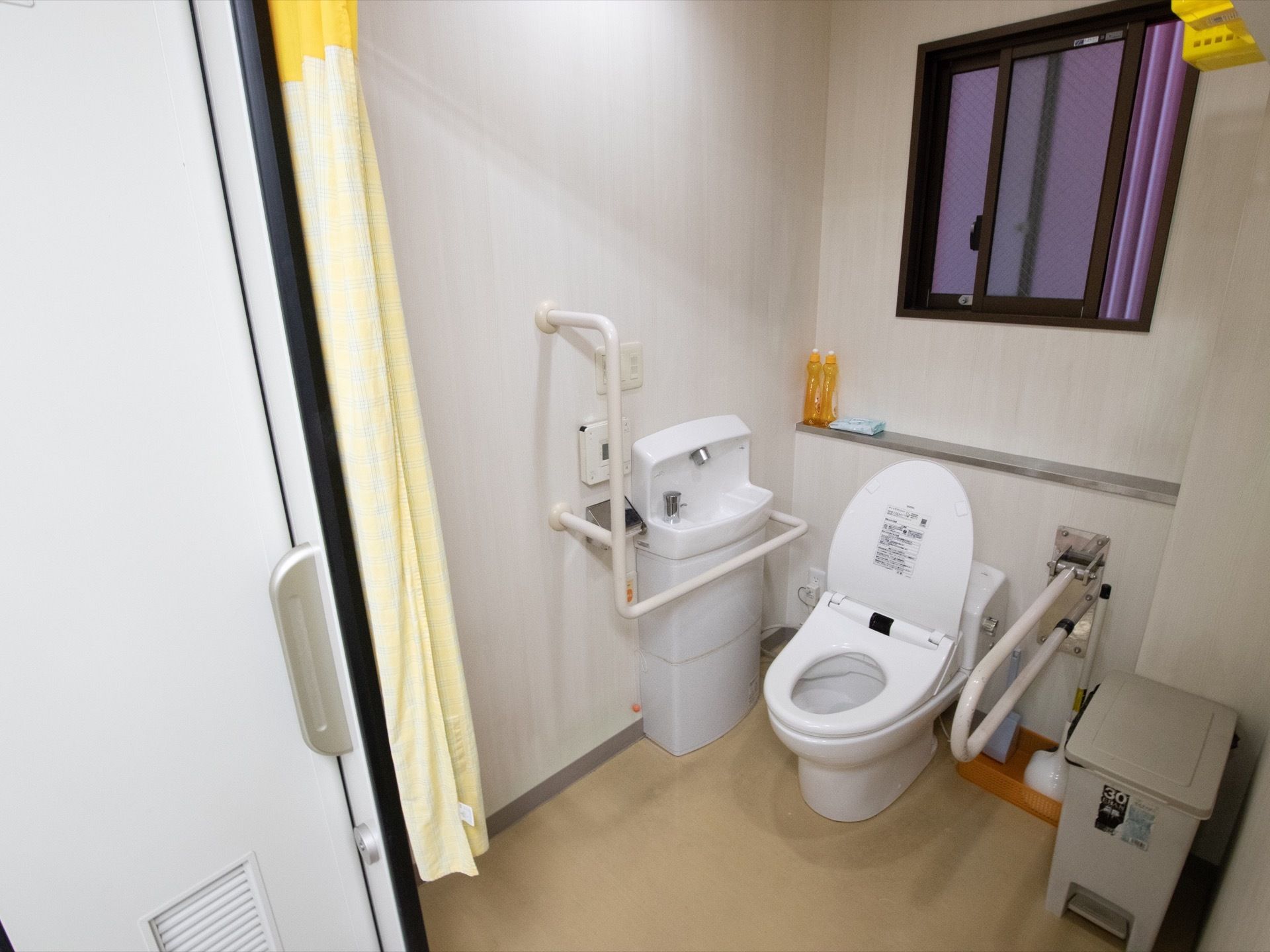 トイレの左右に手すりが付いているため高齢者の方も安心して使える造りになっている。手洗いの水道もすぐ傍にある。
