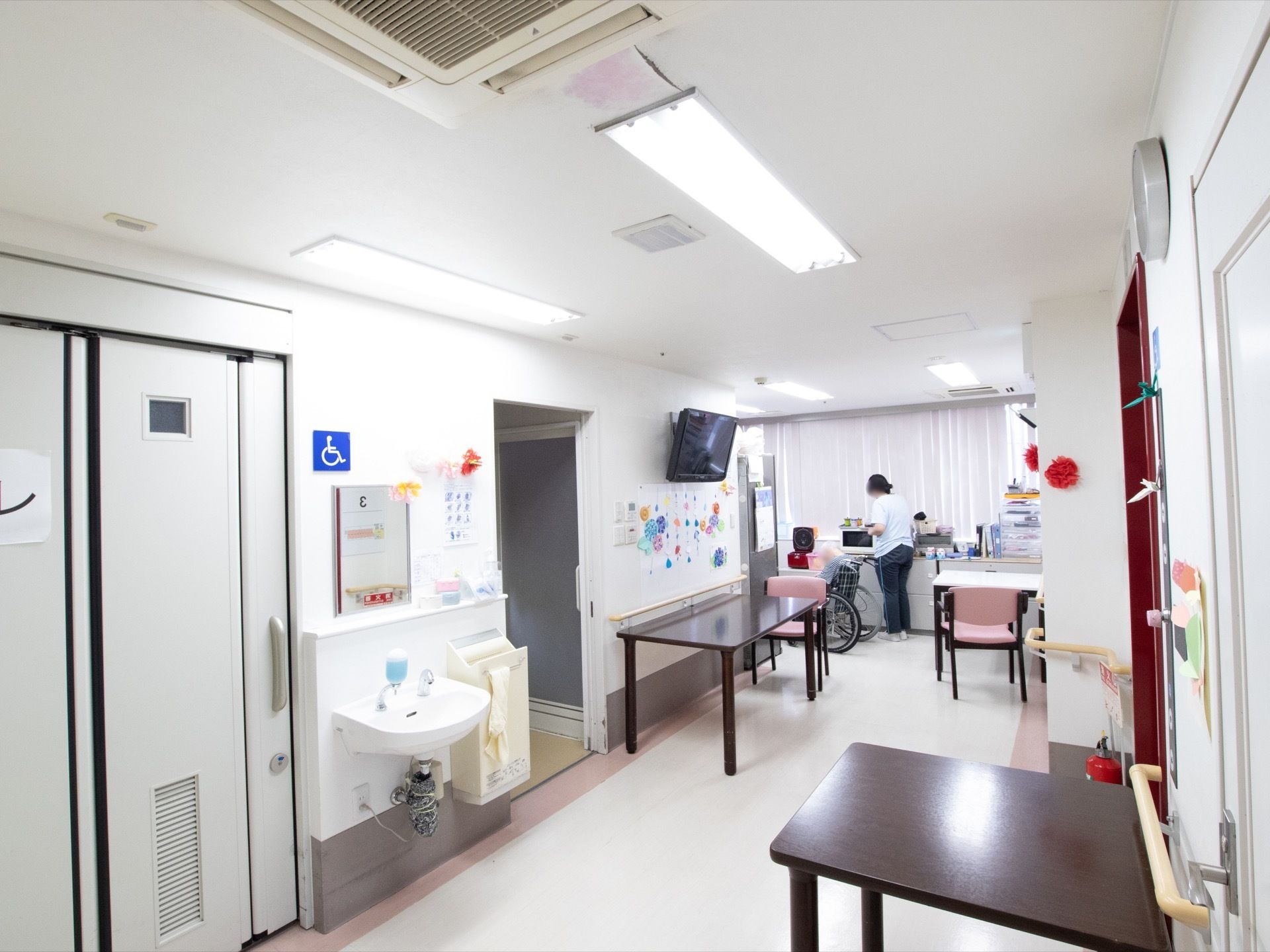 白を基調とした空間は、清潔感が溢れる。広い廊下、そして手すりや洗面台などの配置は、車椅子をご利用の方への配慮が感じられる。