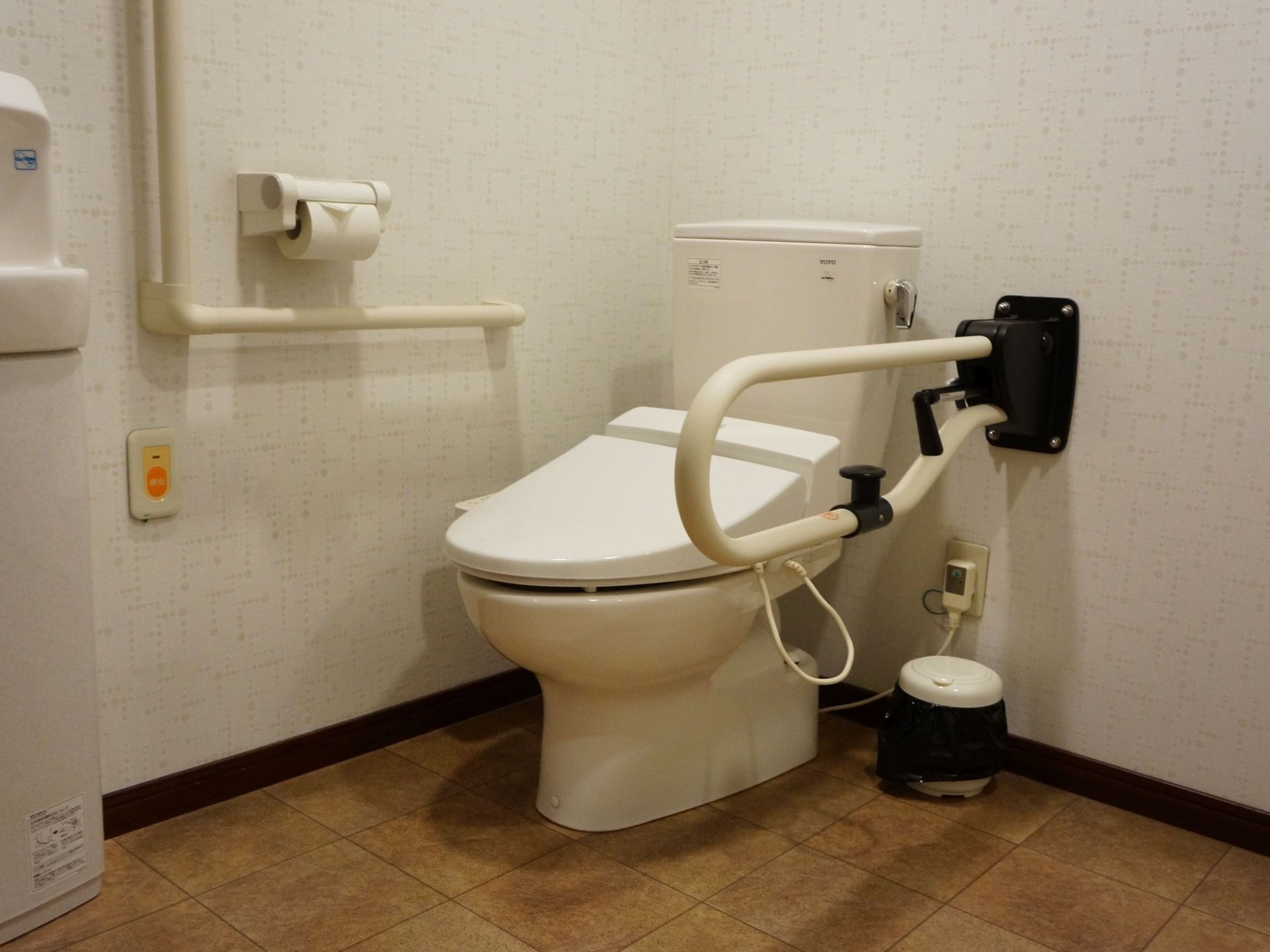広々としたスペースのある室内には、タンク付きのトイレが設置されている。左側の壁には、簡易手洗い場も完備されている。