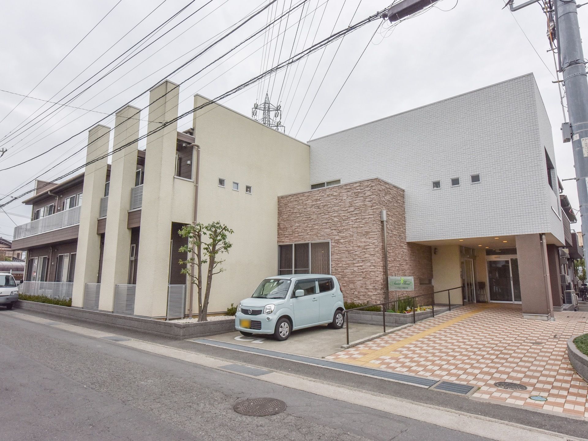一部レンガ造りになっていてとてもモダンな建物である。周囲の街並みにも溶け込んでいる。樹木が１本植えられている。
