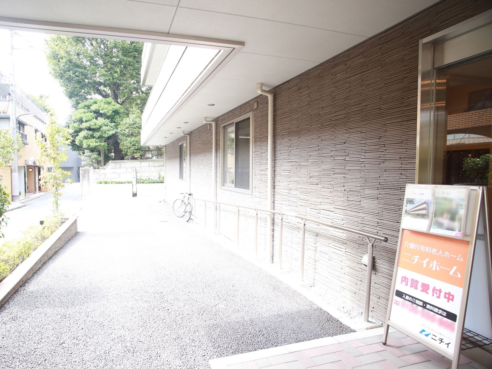 玄関周りにはスロープが造られており、手すりも設置されている。玄関前には内覧受付中と書かれた立て看板が置かれている。