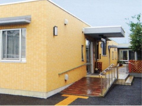 黄色を基調とした明るめの外壁。駐車場から入口までの間はバリアフリー仕様