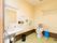 広々としたスペースのトイレである。壁には、エル型の手すりを取り付け、絵を貼っている。前方の横側には、洗面台を備えている。