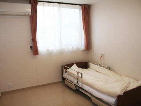 カーテンのかかった窓が柔らかい光が入ってくる、ベッドの置かれた部屋