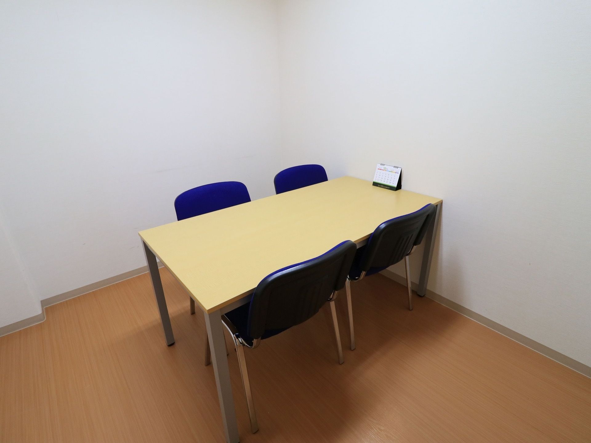 小さな部屋に、テーブルと4脚の椅子が置いてある。テーブルの上には卓上カレンダーがあり、日付を見ながら話ができる。