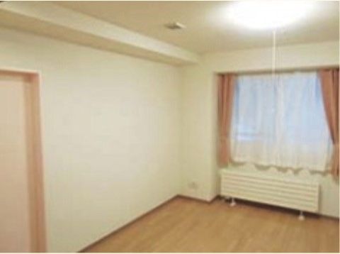 広々とした作りの明るい部屋。壁には大きめの窓を設け、カーテンを掛けている。天井には大型の照明を設置している。
