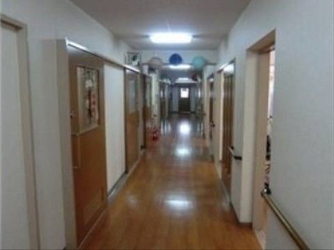 壁は白く、床とドアは木調になっている落ち着いた雰囲気の廊下