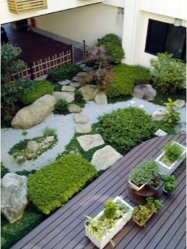 建物に囲まれて設置されている、きちんと手入れされた日本庭園