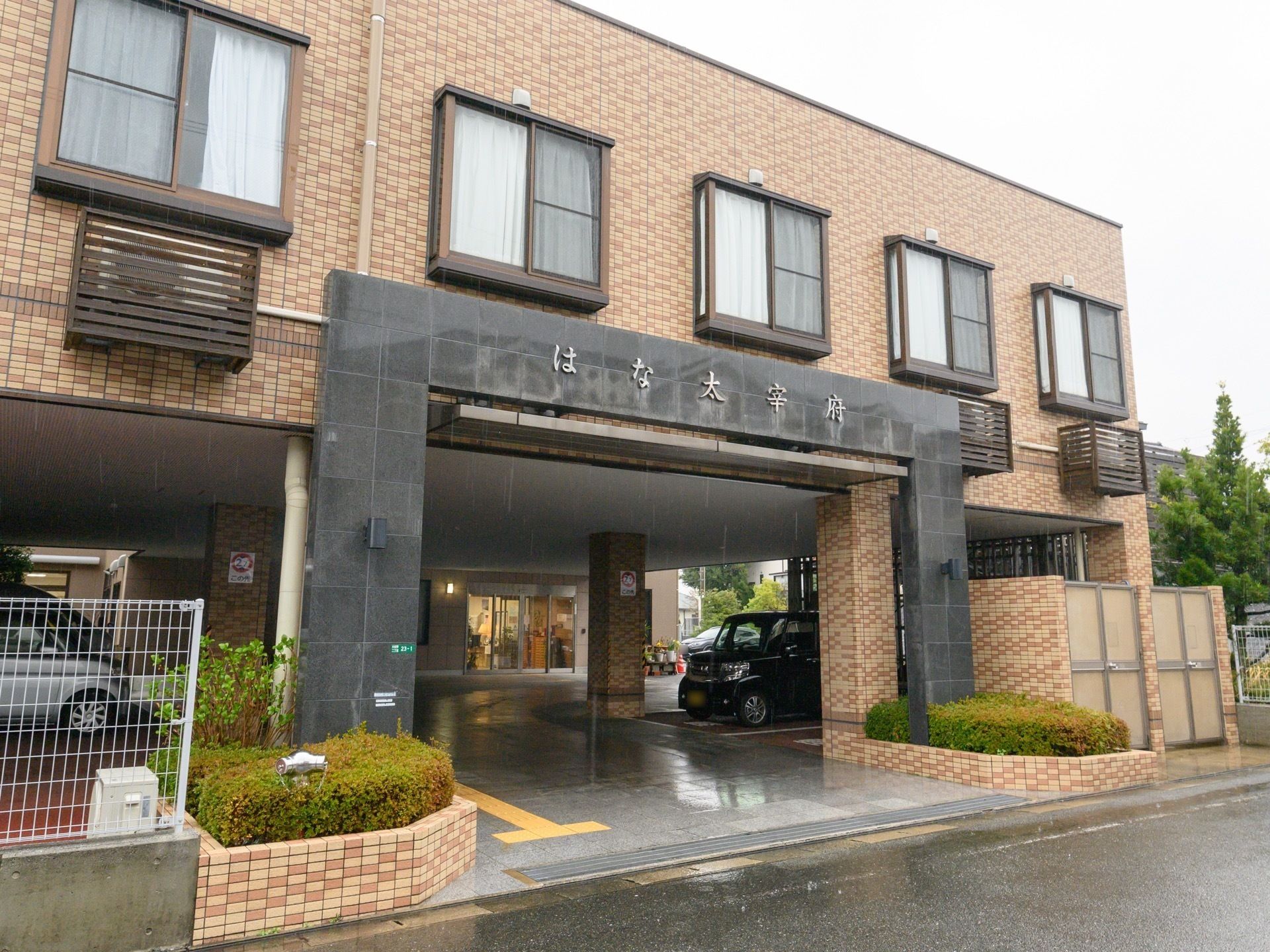 レンガ調の外壁で、一階が駐車場になっている二階建ての建物