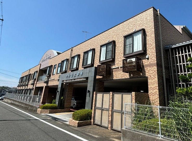 施設名が記されている黒い石製のアーチをくぐると、駐車場と入口がある。駐車場は一台分ごとに、白い線で区切ってある。