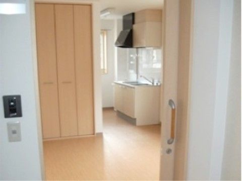 居室内で、開いた扉の向こうに見えているミニキッチン