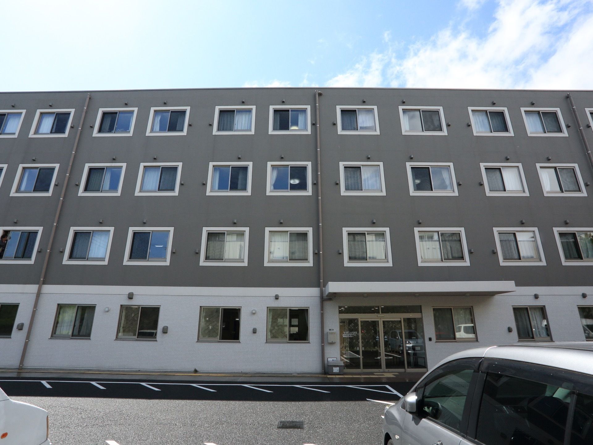 グレーと白のツートンがシックな印象の建物。４階建ての鉄筋コンクリート造りなので、しっかりとした安心感を感じる。