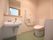 さわやかなグリーンの床色に造られた、清潔感あるトイレである。洗面台の上に棚が設けられ、手洗いソープが置かれている。