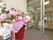 自動ドアの玄関の前に大きな花瓶に活けられた花が飾られている。玄関の足元は物が少なく、スッキリと片ついている。