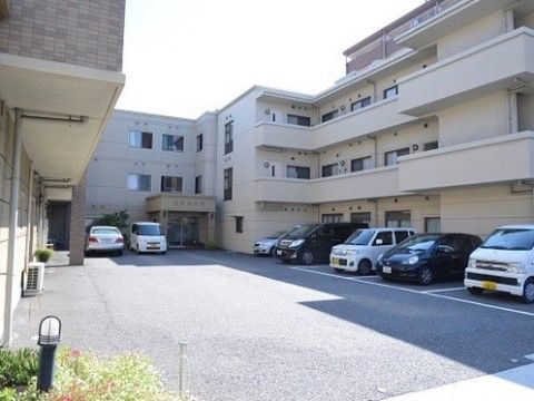「明日香の里（介護付）」の外観。来訪者が車で来た際に止められる駐車場を完備している。