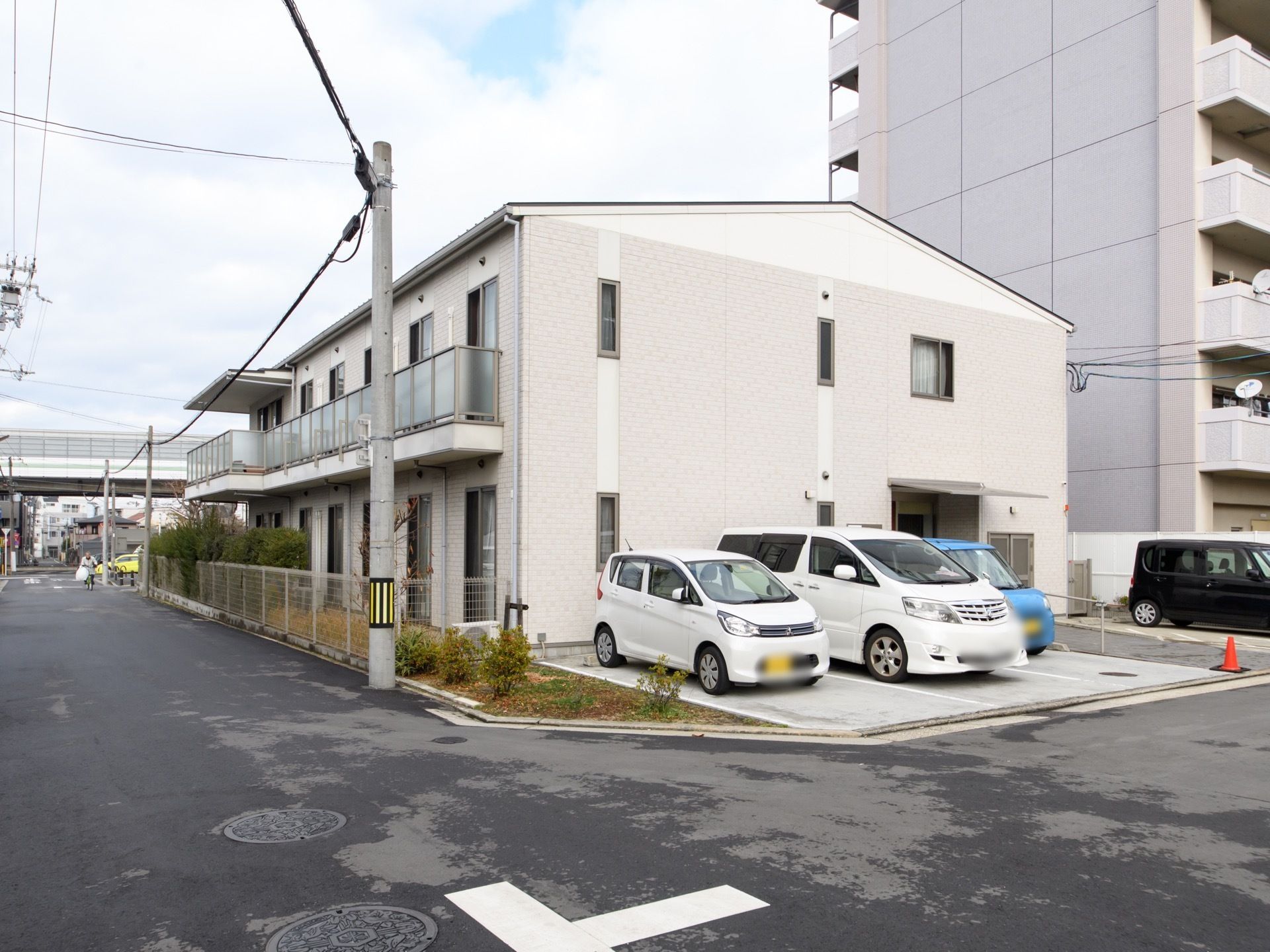 施設は道路に面して建てられている。施設の入口横には車の駐車スペースがある。4台ほどの車が止められる。