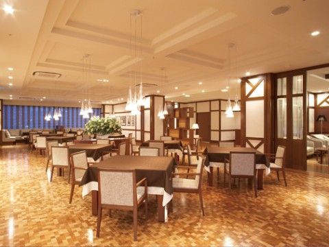 茶色を基調としたテーブルセットが複数設置されている、広々としたダイニング
